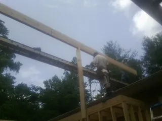 Carpenter setting a ridge beam over a new addition frame — Ice Dam Removal by Roofing Brothers in Hood River