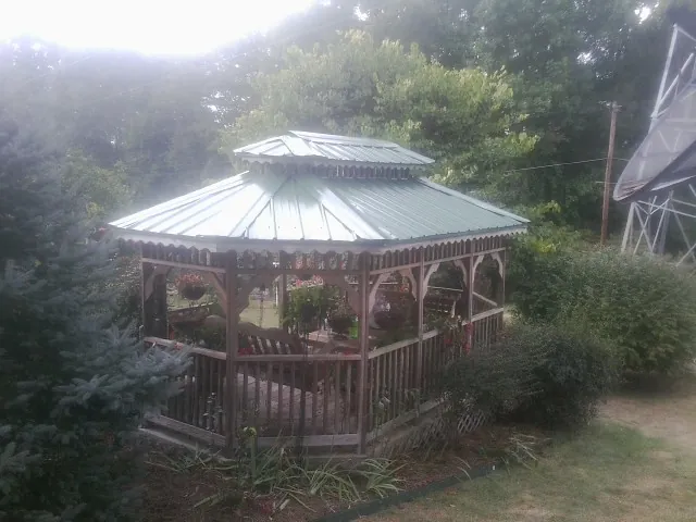 Green metal roof on a backyard gazebo surrounded by garden beds in Hood River