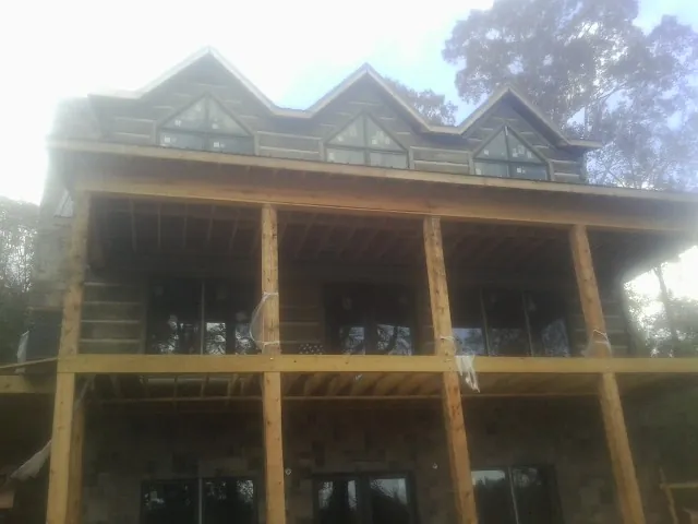 Dormers and porch framing on a large log home under construction — Roof Coating work by our crew in Hood River