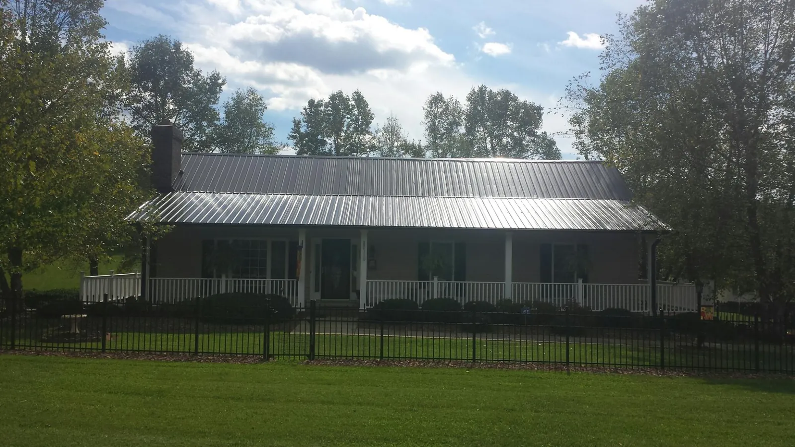 Gray metal roof on a brick ranch with a full width front porch — Gutter Guard Installation work by our crew in Hood River