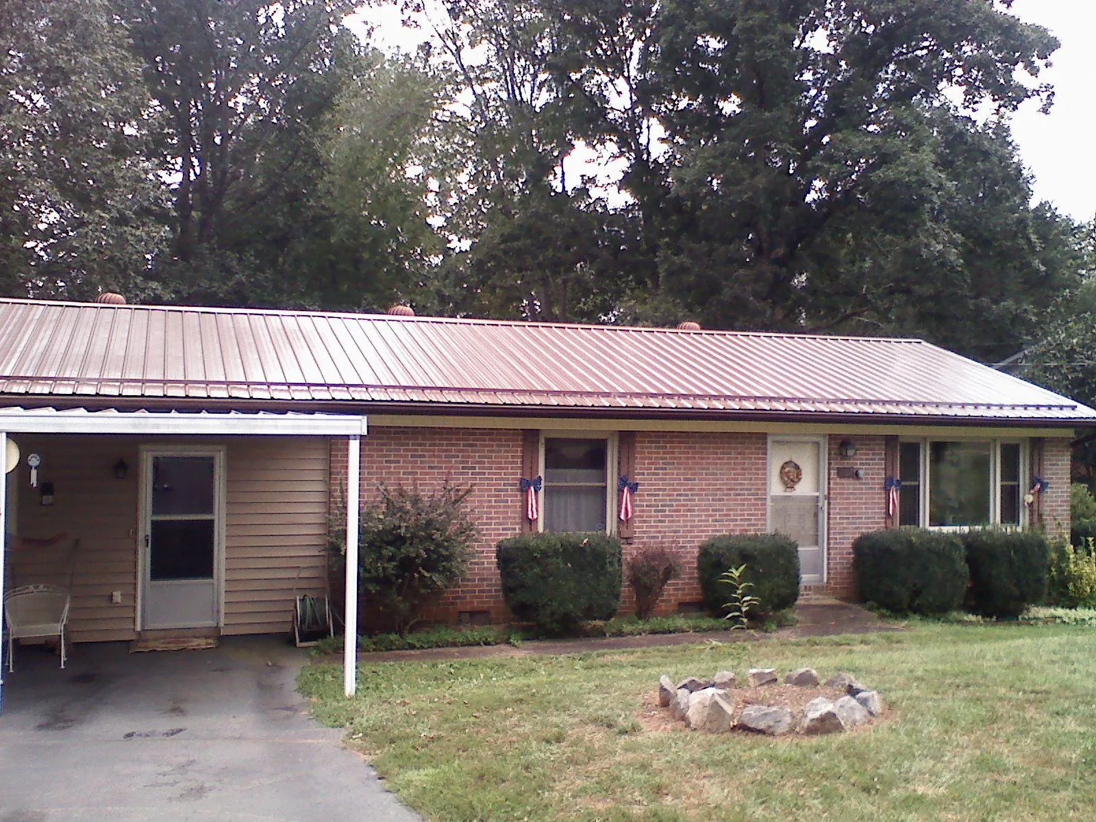 Bronze metal roof and carport on a brick ranch home — Roof Repair work by our crew in Hood River